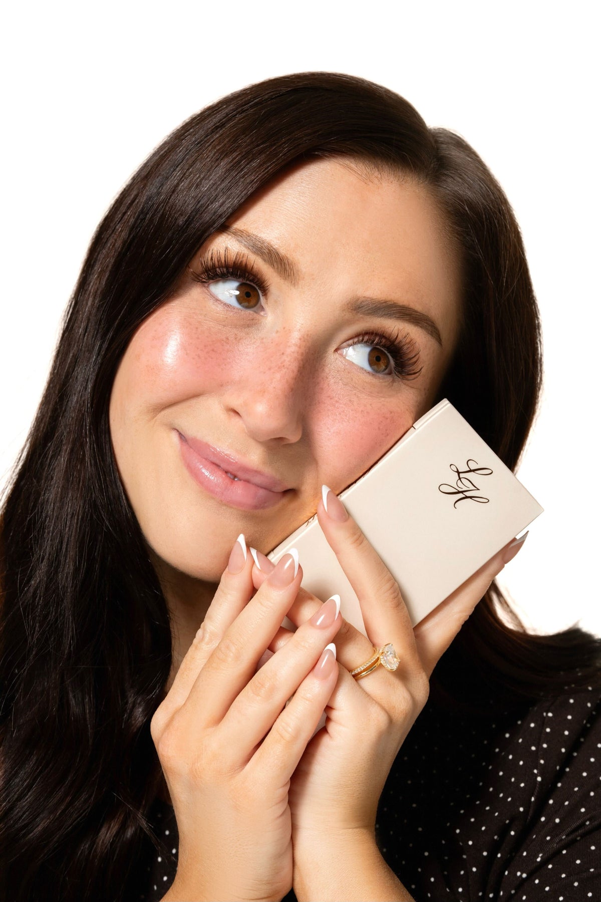 Maddi Morris, founder of Light Heart, holding a Light Heart box beside her face
